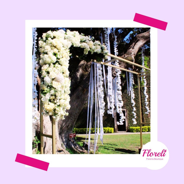 Elegant table centerpiece with red roses in glass vases filled with water, red rose petals scattered on white tablecloth, formal place settings visible